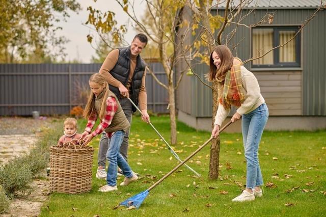 family raking leaves